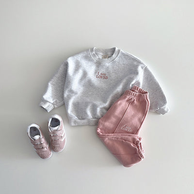 Pink pintuck toddler pants matched with 'I am LOVED' grey sweatshirt for spring.